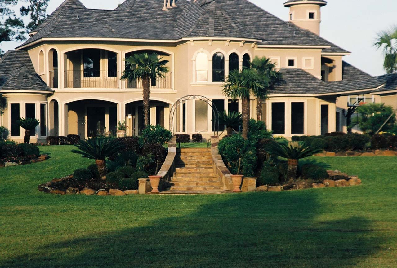 Castle Estate — rear landscape with flagstone steps and palm trees, Magnolia TX