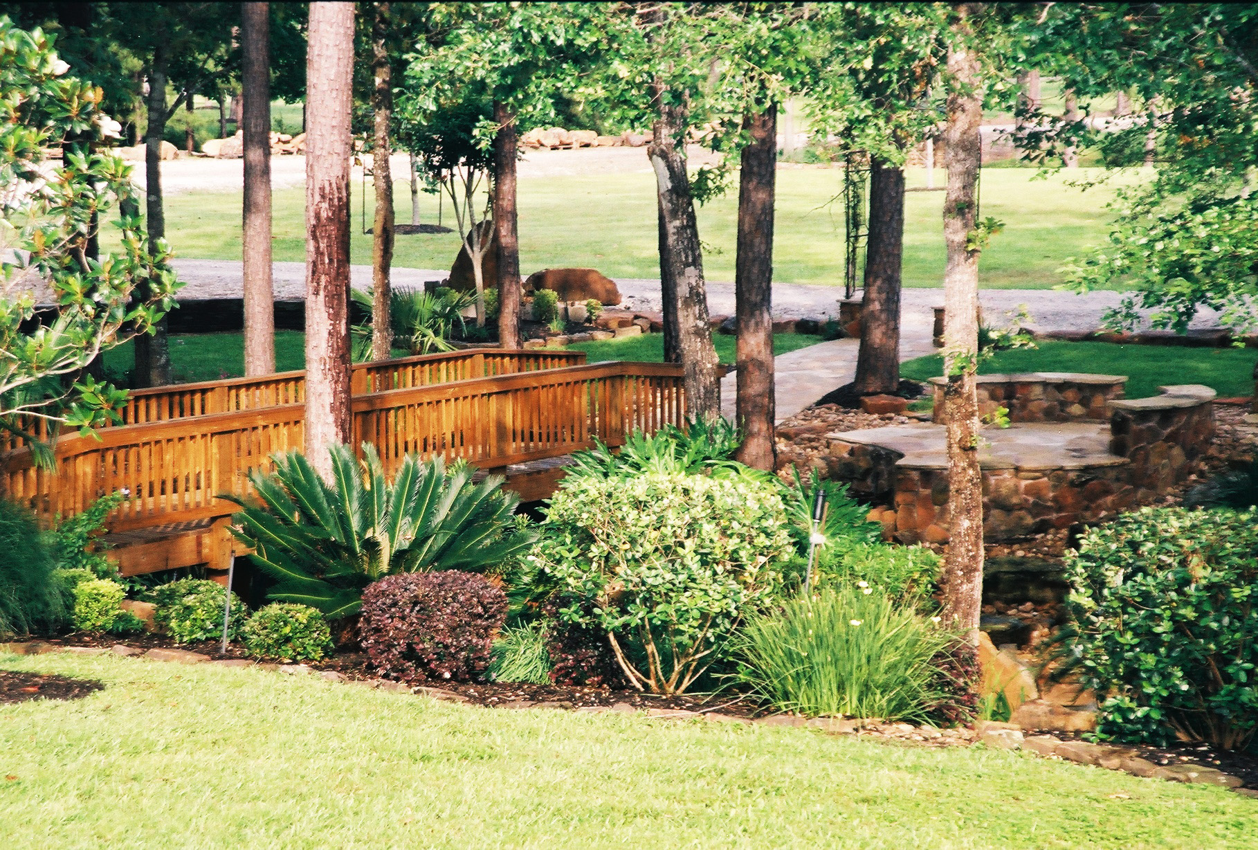 Castle Estate — wooded bridge, flagstone path, naturalistic planting