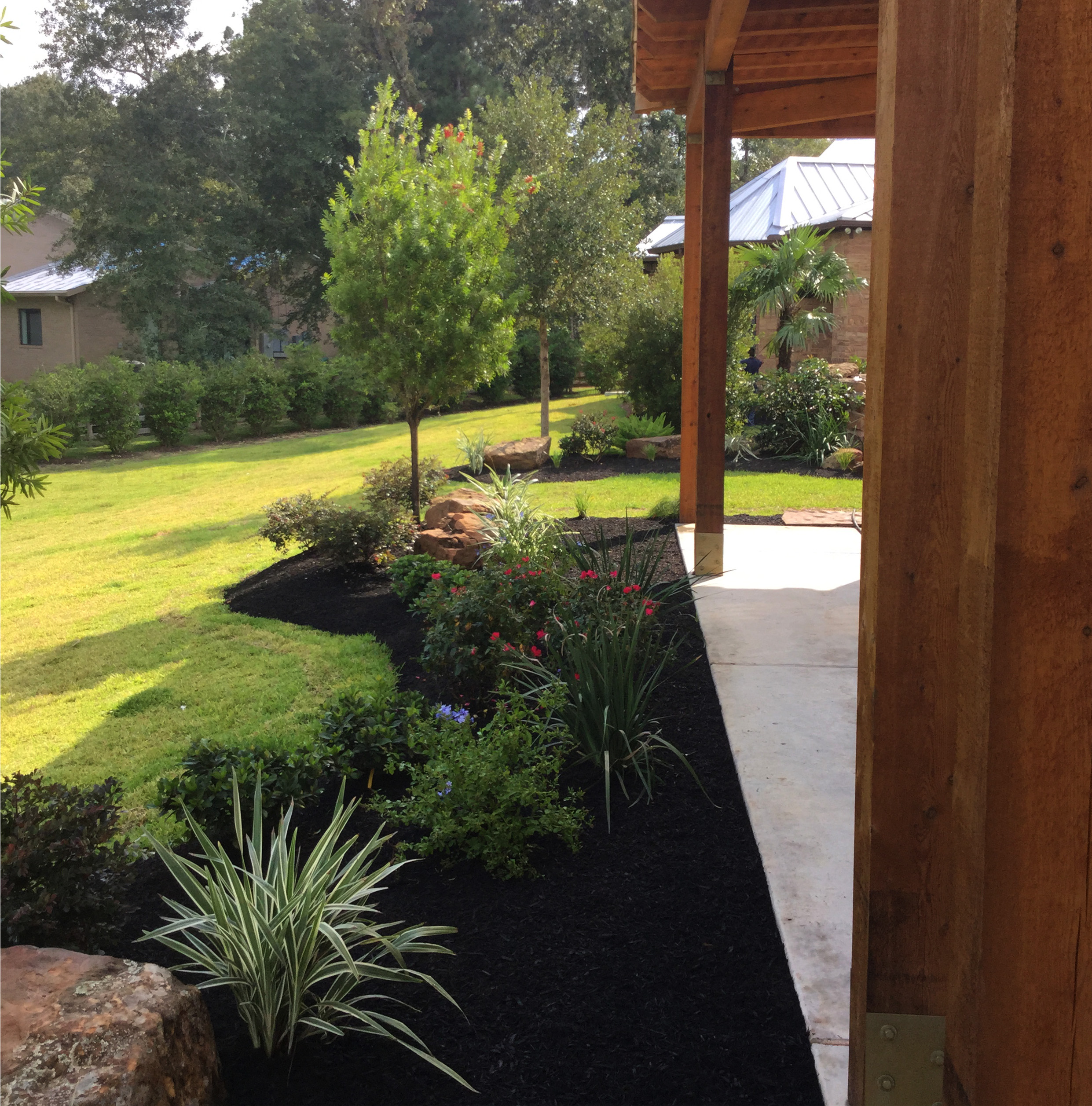 Backyard landscape with covered patio and ornamental beds — New Yards Landscaping