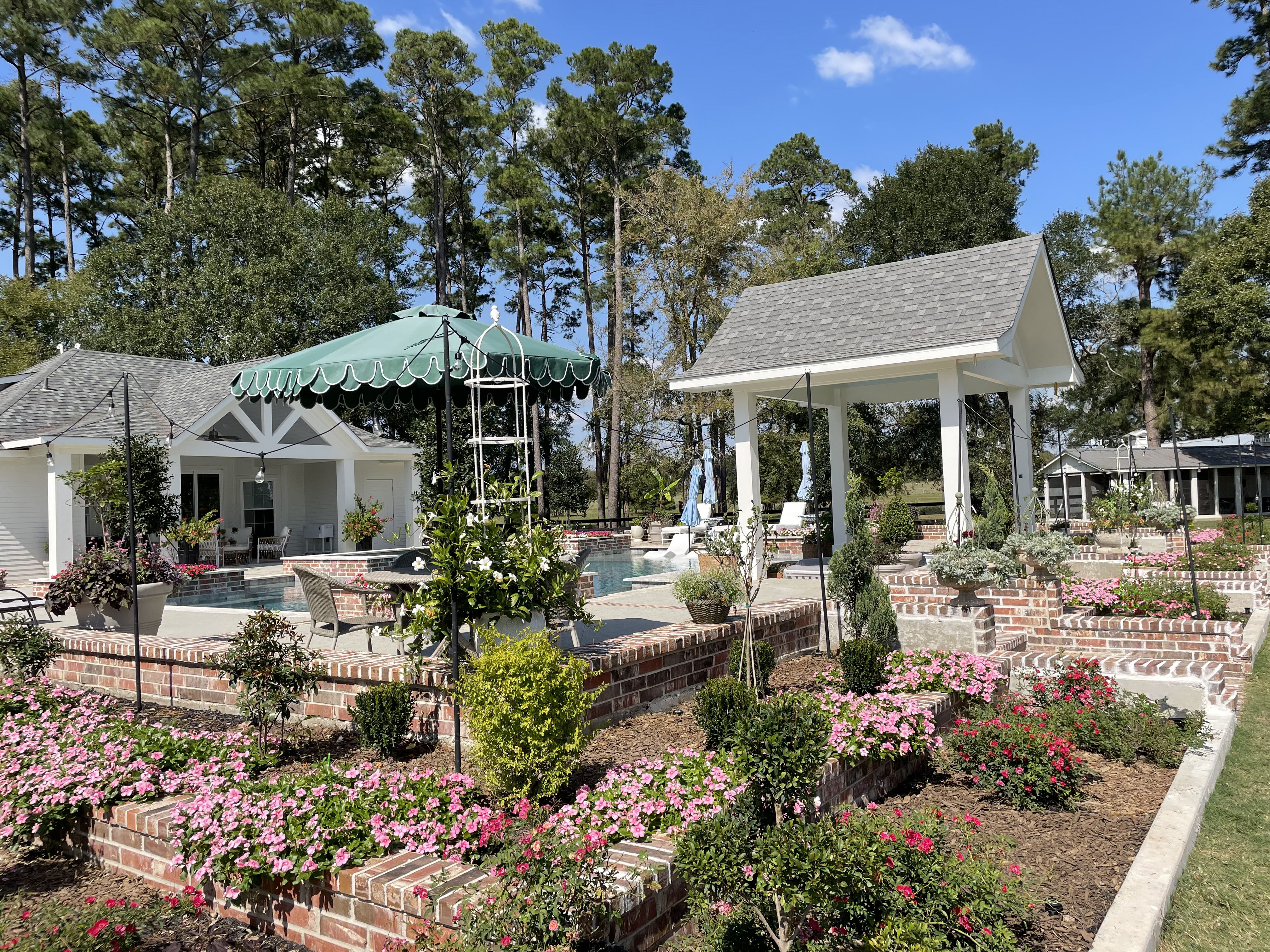 Pool area with raised planting beds pavilion and stonework The Woodlands TX — New Yards Landscaping