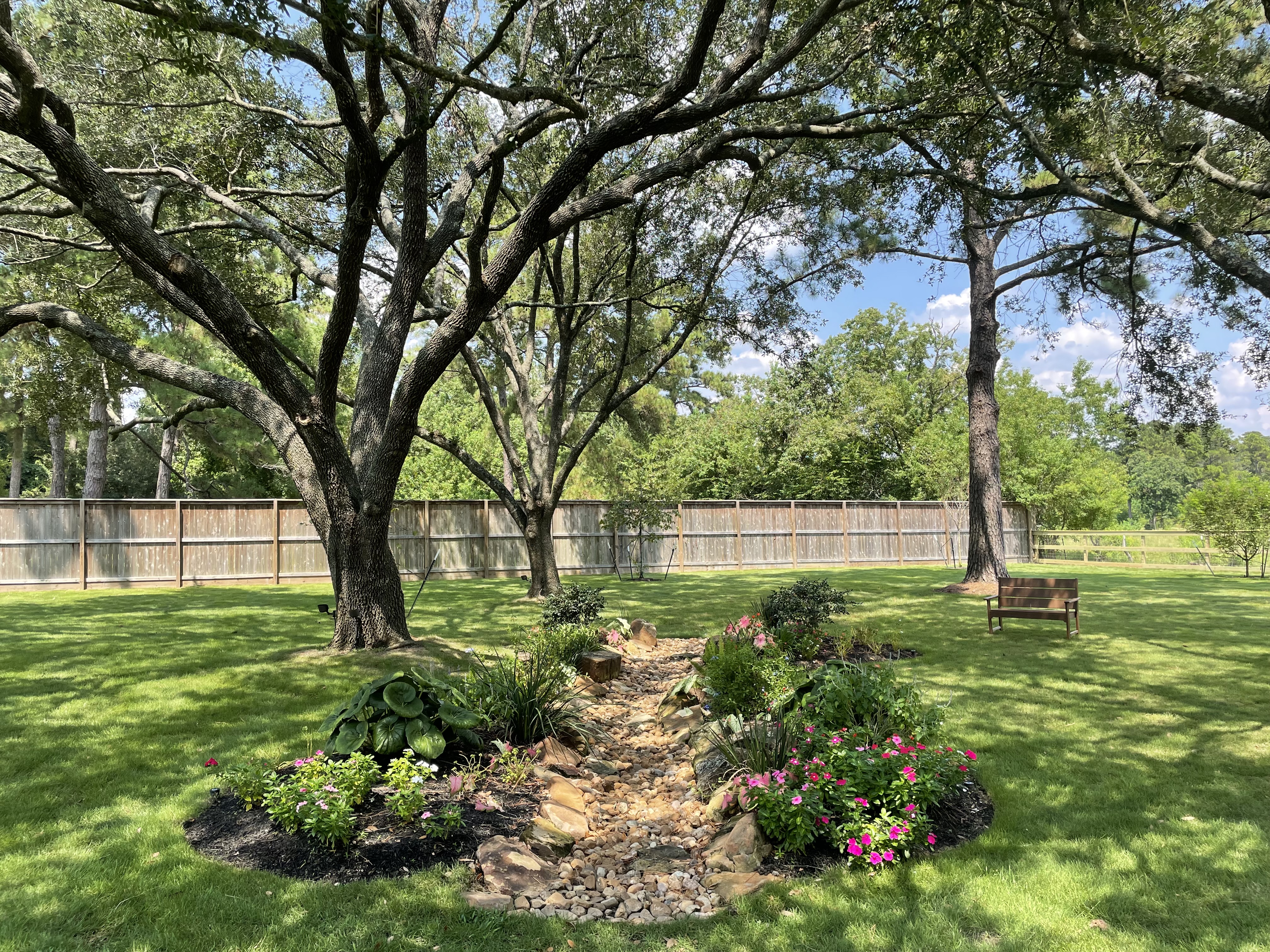 Landscaping in Montgomery TX — dry creek bed and natural stone on large acreage property — New Yards Landscaping